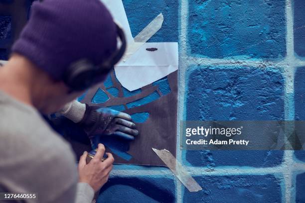 Caz.l sprays over a stencil while taking part in Hands off the Wall street art festival on September 23, 2020 in Munich, Germany. The Hands Off The...