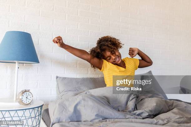 junge afroamerikanische mädchen aufwachen - morning bed stretch stock-fotos und bilder