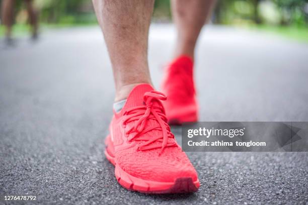 man jogging in park with red sport shoe. - red shoe stock pictures, royalty-free photos & images