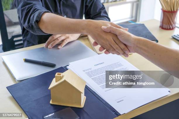 close up real estate agent offer home ownership and life insurance to client.or buy house and real estate. - signing mortgage stock pictures, royalty-free photos & images