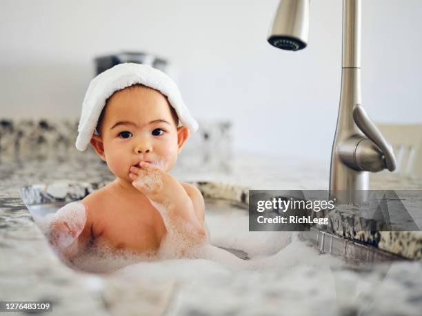 bebé tomando un baño de fregadero de cocina - taking a bath fotografías e imágenes de stock