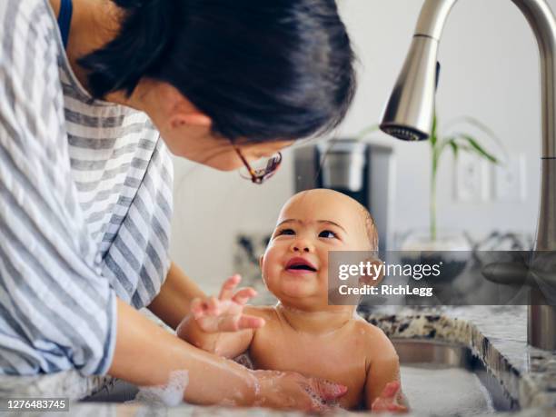 baby taking a kitchen sink bath - hot spring stock pictures, royalty-free photos & images