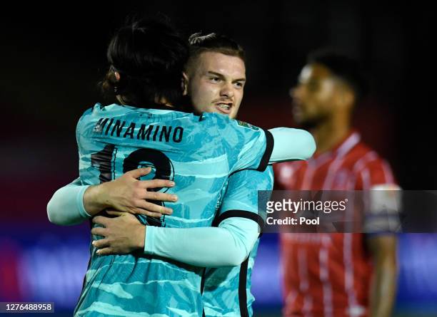 Takumi Minamino of Liverpool celebrates with Harvey Elliott of Liverpool after scoring his teams second goal during the Carabao Cup third round match...