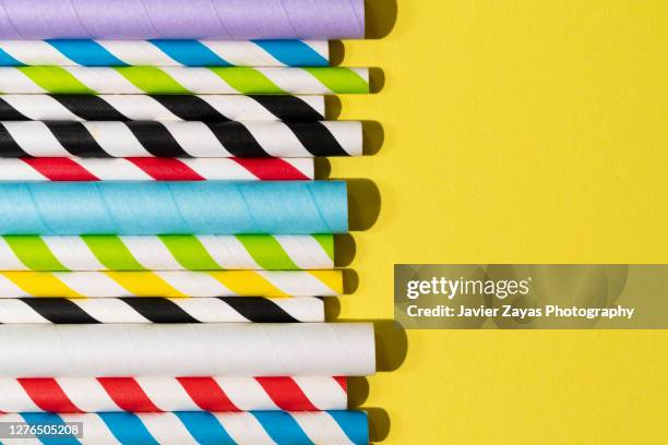 many paper drinking straws on yellow background - rietje stockfoto's en -beelden