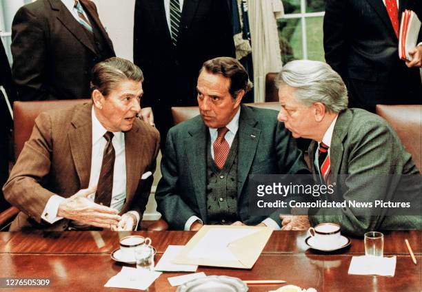 During a meeting with a bipartisan group of Congressional leaders, US President Ronald Reagan confers with US Senate Majority Leader Bob Dole and US...