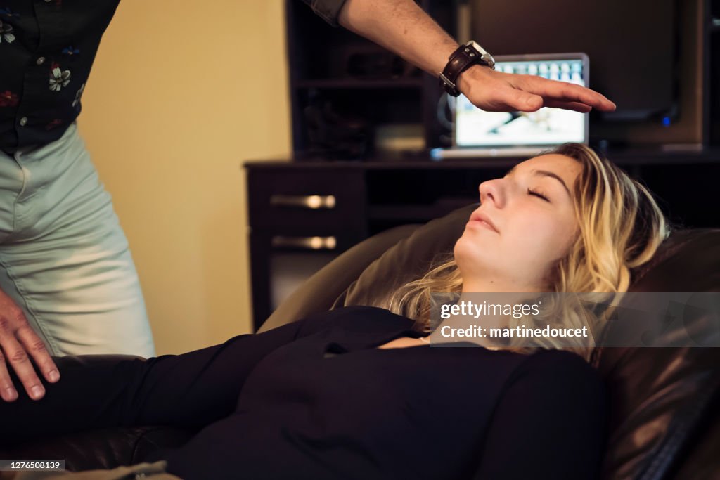 Young woman with hypnotherapist in session.