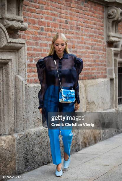 Leonie Hanne is seen wearing navy sheer top, Valentino bag, blue pants outside Max Mara during the Milan Women's Fashion Week on September 24, 2020...