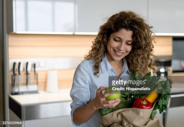 mujer que llega a casa después de comprar alimentos - woman carrying tote bag fotografías e imágenes de stock