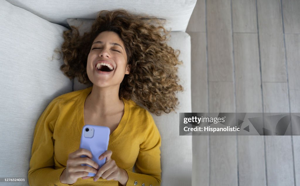 Woman laughing after watching something funny on her cell phone