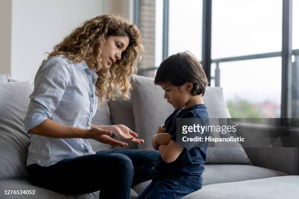 boy having a tantrum at home and mother trying to talk to him - repreensão imagens e fotografias de stock