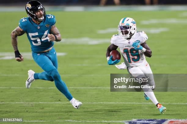 Jakeem Grant of the Miami Dolphins runs for yardage against Cassius Marsh of the Jacksonville Jaguars during the first quarter of a game at TIAA Bank...