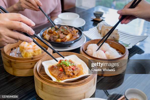 people eating guangdong dum sum with chopsticks in the restaurant - guangdong province stock pictures, royalty-free photos & images