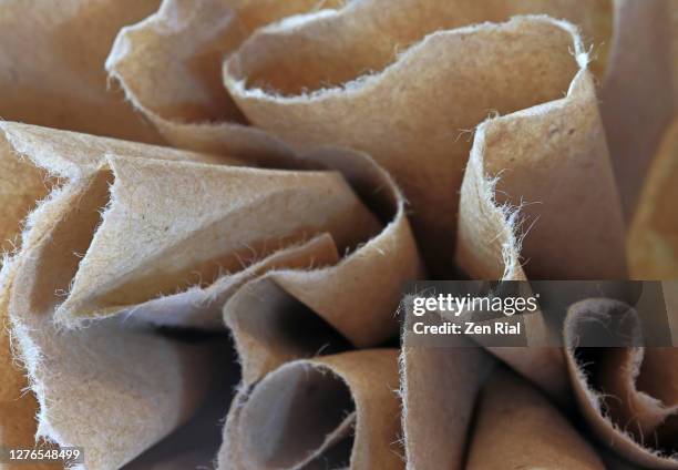 close up of torn brown paper gathered to show edges in full frame horizontal format - gerafft stock-fotos und bilder