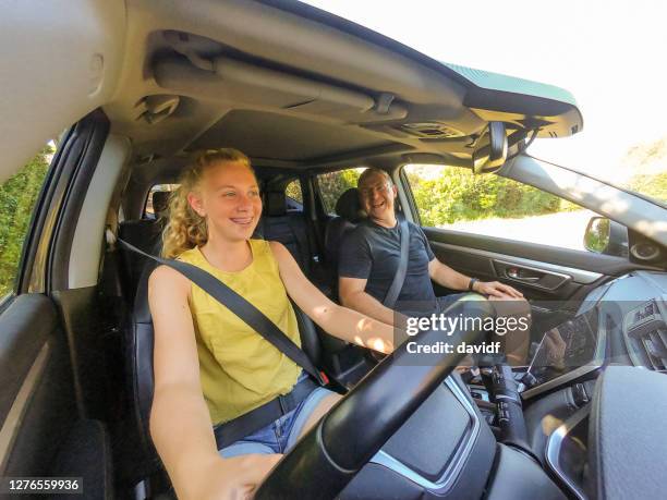 happy teenage girl learning to drive a car - driving australia stock pictures, royalty-free photos & images