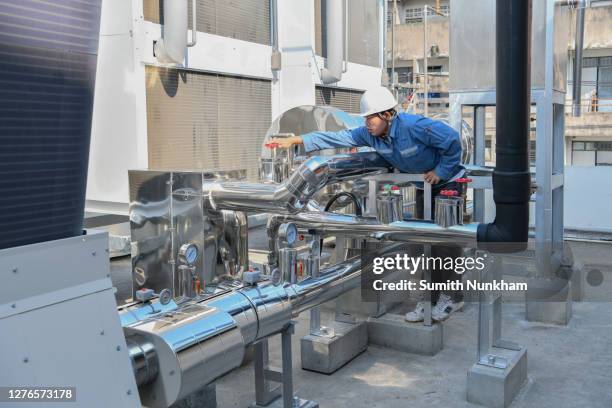 industrial engineer tuning valve of flow rate and checking temperature on pressure gauge of cooling water system in the factory - chillar stock pictures, royalty-free photos & images