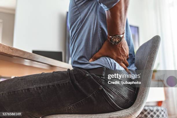 die strapazen eines langen tages an seinem schreibtisch spüren - niedrig stock-fotos und bilder