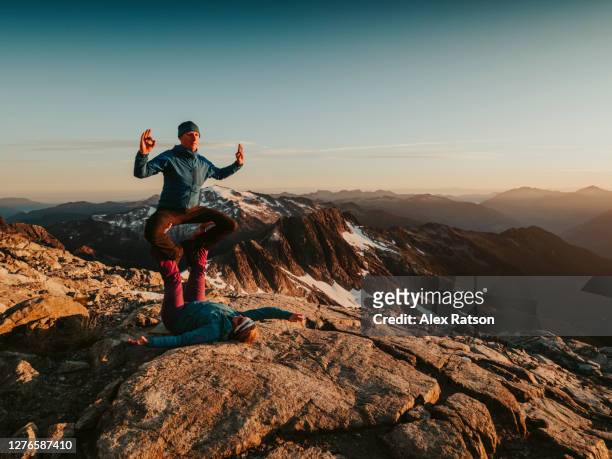 a strong female fly’s her male partner while performing acro yoga on mountain top - s the adventures of rin tin tin stockfoto's en -beelden