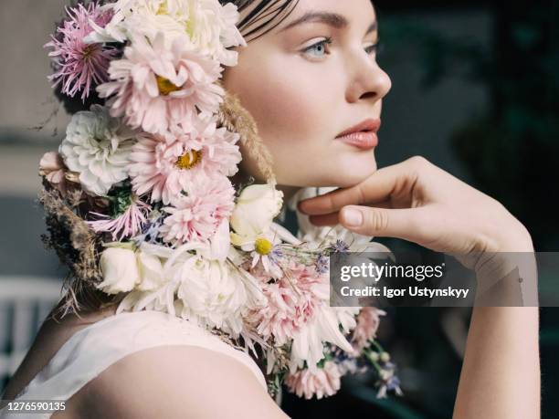 profile view of young woman in floral headdress - bloemkroon stockfoto's en -beelden