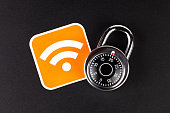 WiFi wireless network security simple abstract concept. Wifi Connection signal symbol and a coded padlock laying on black background. Securing, mobile internet data safety in public hotspots