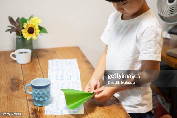 a boy playing with folding origami - origami asia stock pictures, royalty-free photos & images