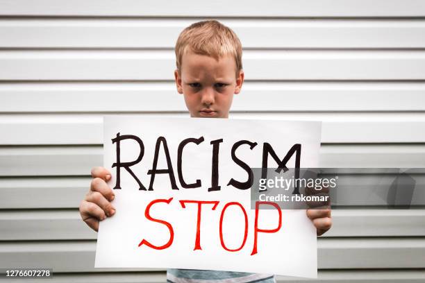 angry child activist holding a poster with a message racism stop. racial demonstration for the ethical rights of african americans. social protest - anti racism children stock pictures, royalty-free photos & images