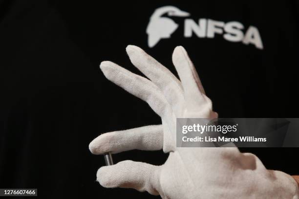 Team member holds the DNA data vial storing Olympic footage of Cathy Freeman at the Museum of Contemporary Art on September 25, 2020 in Sydney,...