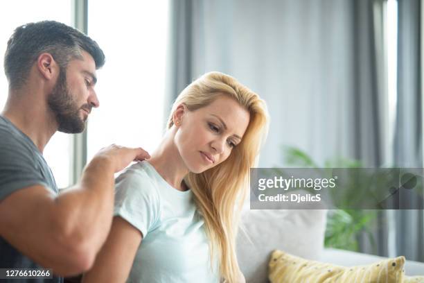 young woman receiving a massage from her husband. - girlfriend massage stock pictures, royalty-free photos & images