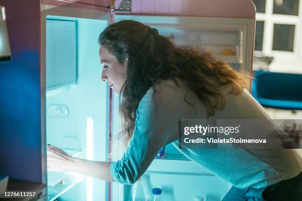 woman taking food from the fridge. - woman refrigerator stock pictures, royalty-free photos & images