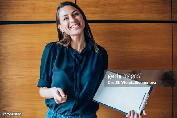young woman showing a blank paper page. - net promoter stock pictures, royalty-free photos & images