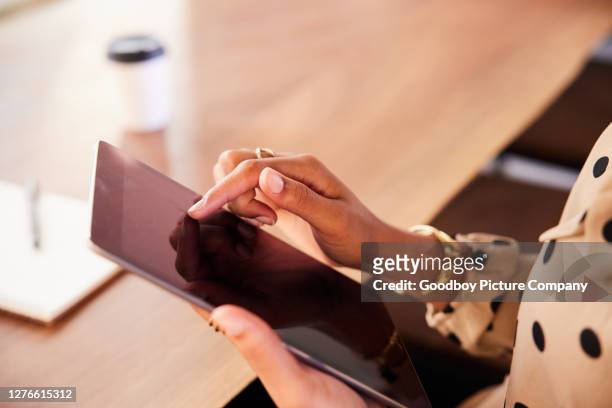 businesswoman sitting at a table using a digital tablet - tablet close up real copyspace stock pictures, royalty-free photos & images