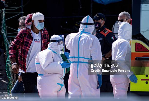 2The first migrant gets off the Alan Kurdi ship and is rescued by medical personnel on September 25, 2020 in Olbia, Italy.