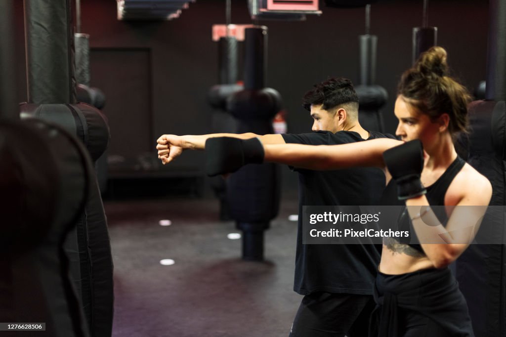 Practising Boxing Young Woman Practicing Boxing Stance And Punches With Personal Trainer ...