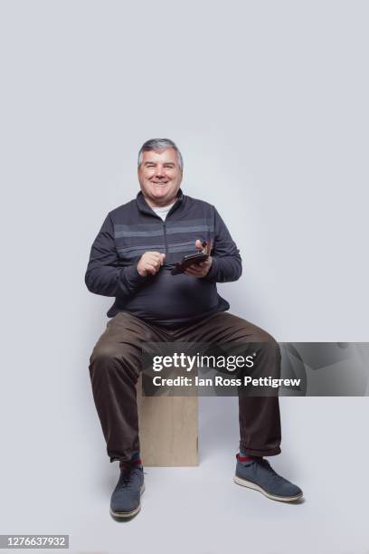 middle-aged businessman on smartphone - chubby men stock pictures, royalty-free photos & images