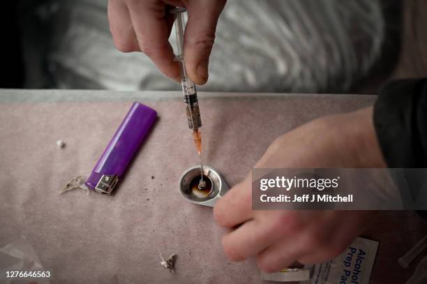 Drug users prepare heroin before injecting, inside of a Safe Consumption van set up by Peter Krykant on September 25, 2020 in Glasgow, Scotland....