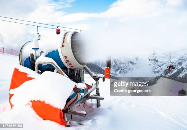 snow machine in use at european ski resort - fake snow stock pictures, royalty-free photos & images