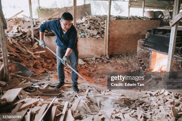 asian chinese man is fire up kiln drying the pottery with tradition oven - pottery kiln stock pictures, royalty-free photos & images