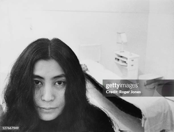 Japanese artist and musician Yoko Ono sits in a white-painted half bedroom entitled 'Half-a-Room', part of her recent avant-garde Half-a-Memory...
