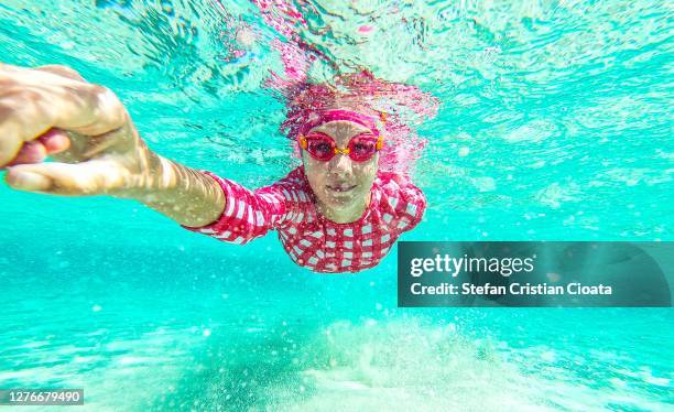 girl swimming underwater at balos beach crete - balonnen stock-fotos und bilder