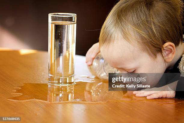boy sipping water from table - niño-tomando-agua fotografías e imágenes de stock