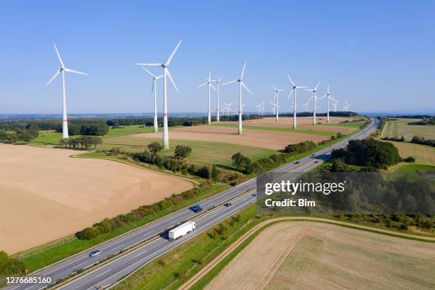 windturbinen-farm in der nähe der autobahn - deutsche autobahn stock-fotos und bilder