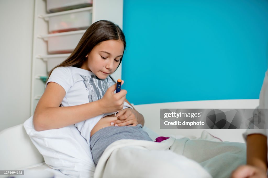 Diabetic girl injecting insulin in hers stomach