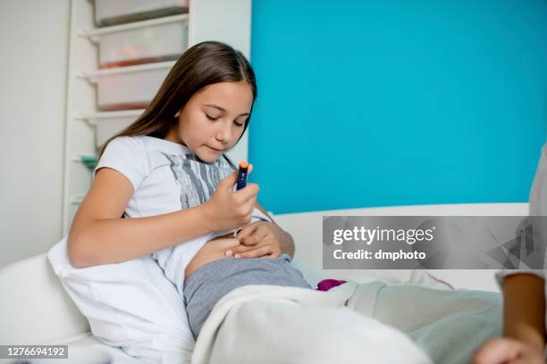 diabetic girl injecting insulin in hers stomach - insulin pen stock pictures, royalty-free photos & images