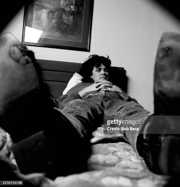 Bassist Paul Langlois of the Canadian rock group The Tragically Hip poses for a portrait while lying on his bed in a hotel room circa February, 1992...