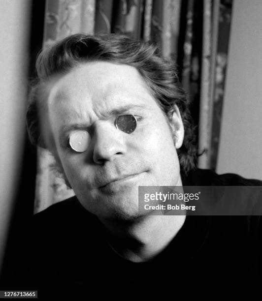 Lead singer Gordon Downie of the Canadian rock group The Tragically Hip poses for a portrait with Canadian silver dollars covering his eyes circa...