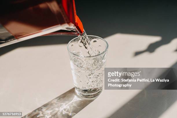 pitcher pouring water in a glass - food contamination stock pictures, royalty-free photos & images