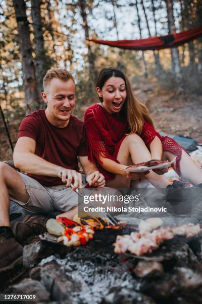 couple preparing a food in nature, campfire - scandinavia picnic stock pictures, royalty-free photos & images