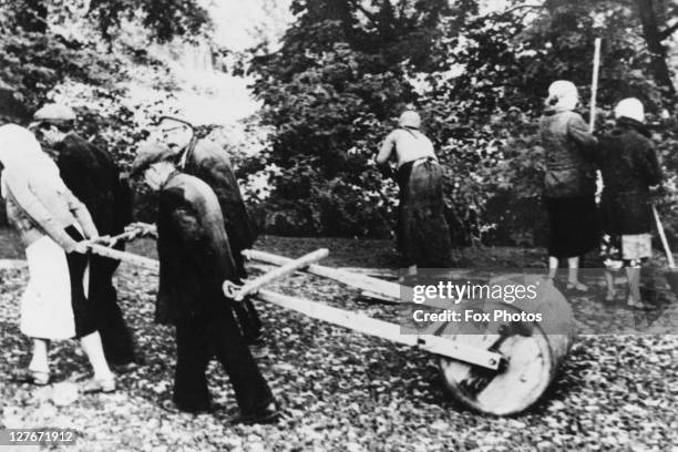 Jewish civilians are forced to pull rollers to repair road damage in Nazi-occupied Poland, March 1941.