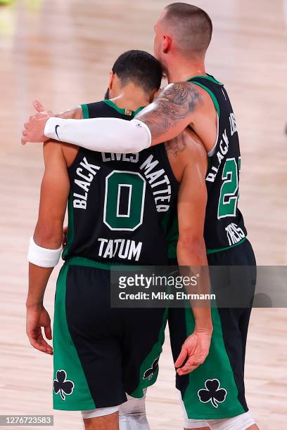 Jayson Tatum of the Boston Celtics and Daniel Theis of the Boston Celtics react after their win over the Miami Heat in Game Five of the Eastern...