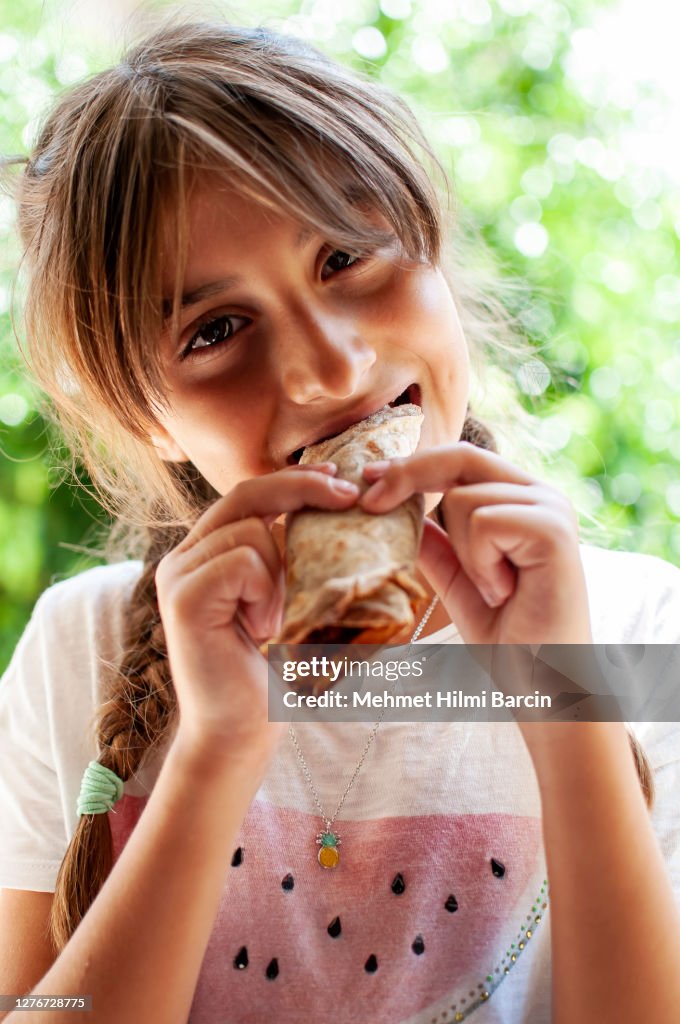 Little girl eating traditional raw Turkish Pizza (Lahmacun)