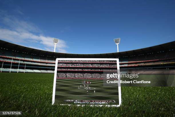 In this before-and-after composite, the print which is dated September 28 shows the first bounce during the 2019 AFL Grand Final match between the...